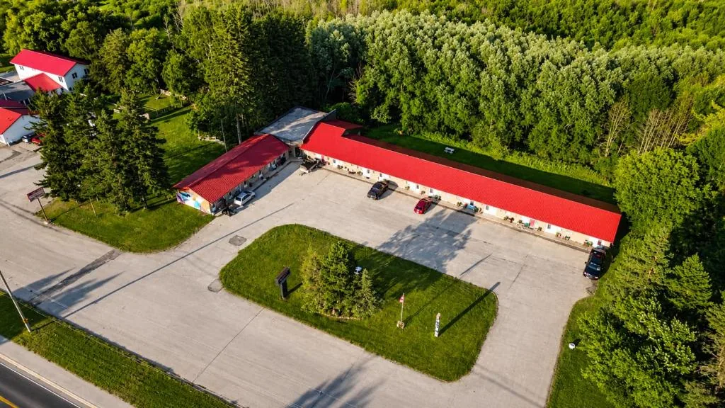 Aerial view of the red-roofed Top Notch Motel property surrounded by trees